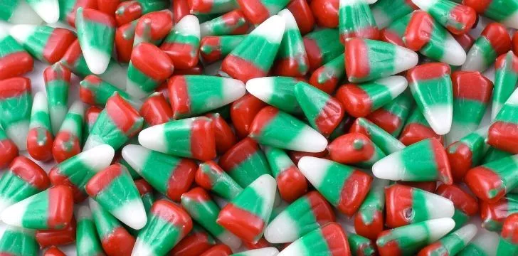 Кратка история на Candy Corn 8 Бонбони с червена линия на дъното, зелена линия в центъра и бял връх.